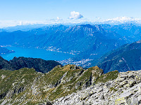 Der Schlussanstieg zur Cima dell'Uomo führt über ein Geröllfeld, tief unten winken der Lago Maggiore und Locarno. : Cima dell'Uomo