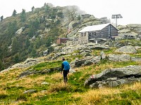 Bei der Bocchette die Cazann setzt Wind ein und aus den Wolken drückt leichter Regen. Wir beeilen uns deshalb und laufen weiter unter der Cima dell' Uomo durch, über die Bocchetta d'Erbea hinunter zur Capanna Albagno, die an diesem Wochenende sogar bewartet ist. Heidelbeerkuchen, Kaffee und Gazosa schmecken in der warmen Stube besonders gut! : Via Alta Verzasca 2025